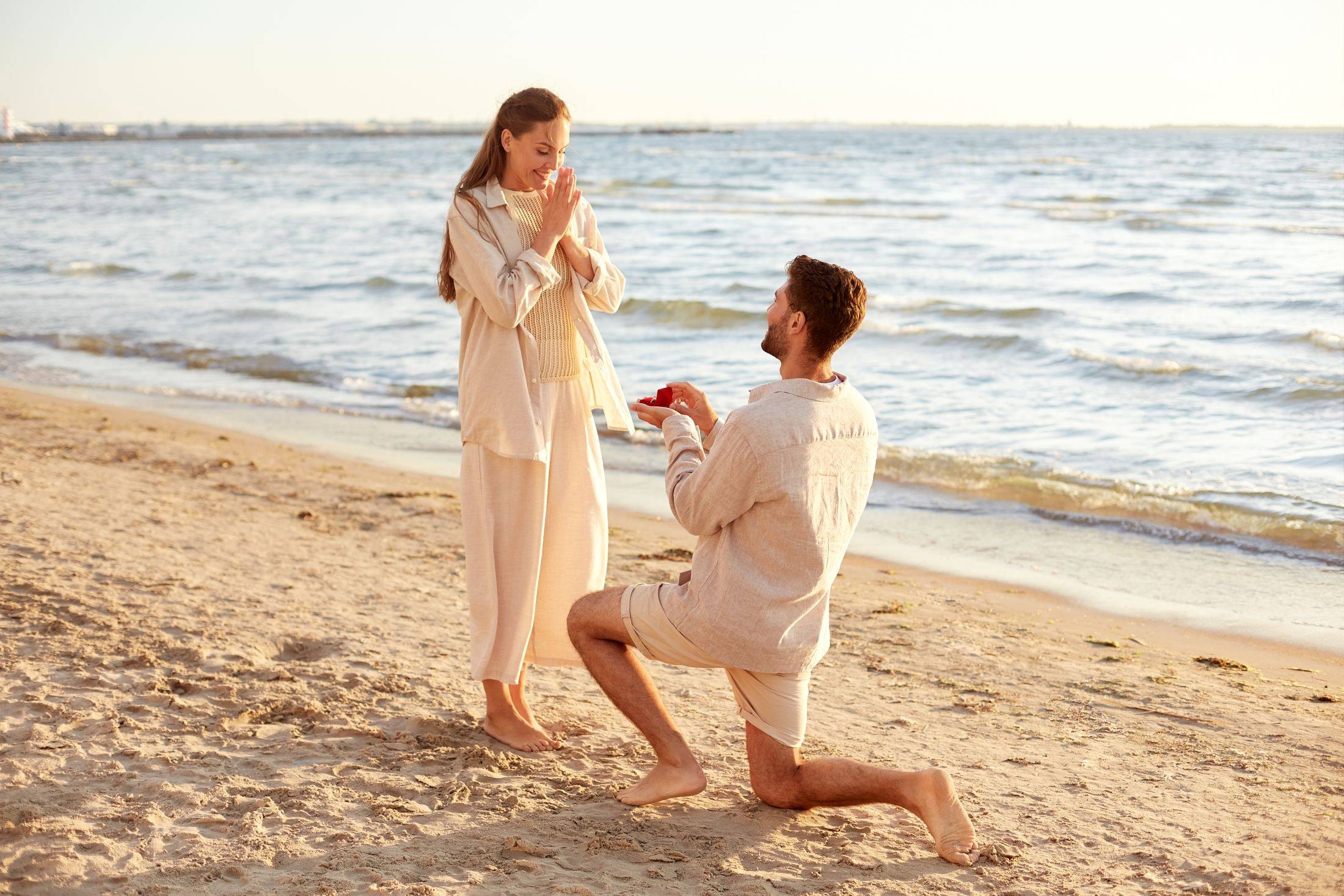 Pareja compartiendo un momento de compromiso en una playa