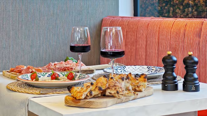Mesa con antipasti, focaccia y vino en Trattoria La Dolce Vita