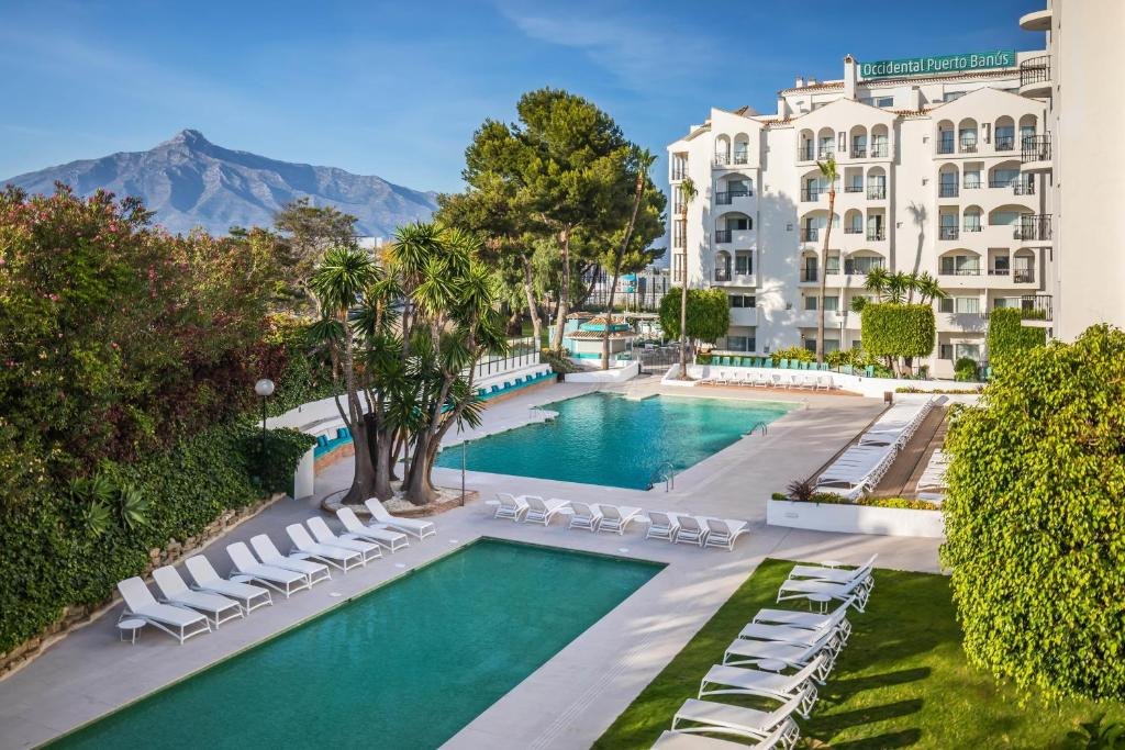 Piscinas y jardines del hotel Occidental Puerto Banús, con La Concha al fondo
